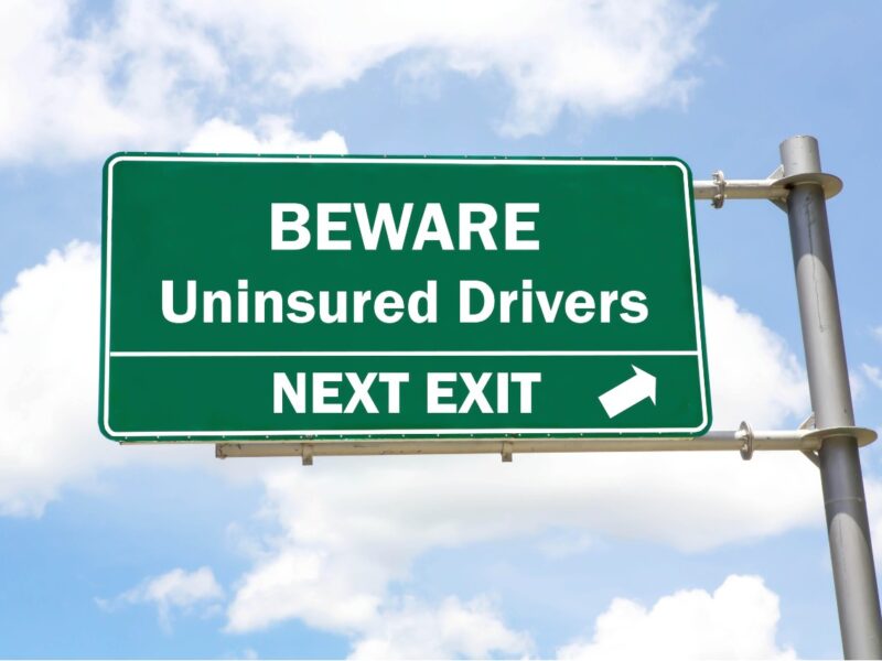 Picture of a highway exit sign which says; beware uninsured drivers next exit