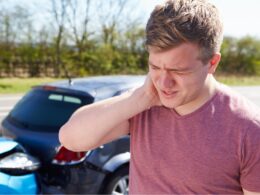 Photo of a man holding his neck after a car accident