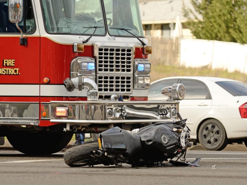 Motorcycle lying in the roadway next to fire truck after an accident