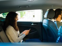 Photo of a young woman passenger in the backseat of a rideshare vehicle