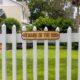 Photo of a beware of dog sign on a wooden fence