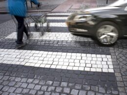 Elderly pedestrian in a crosswalk with a vehicle approaching