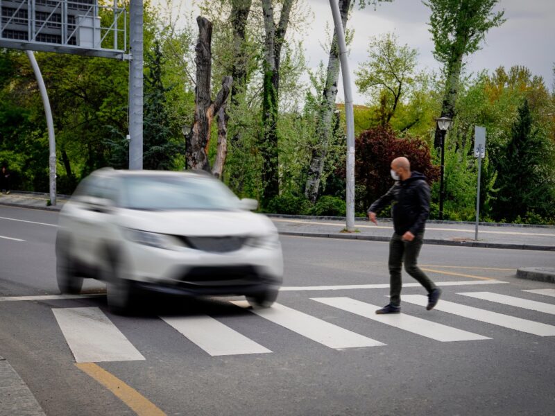 Photo of a pedestrian in a crosswalk with a vehicle quickly approaching