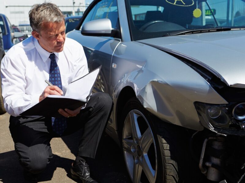 photo of an insurance adjuster writing an estimate after a car accident