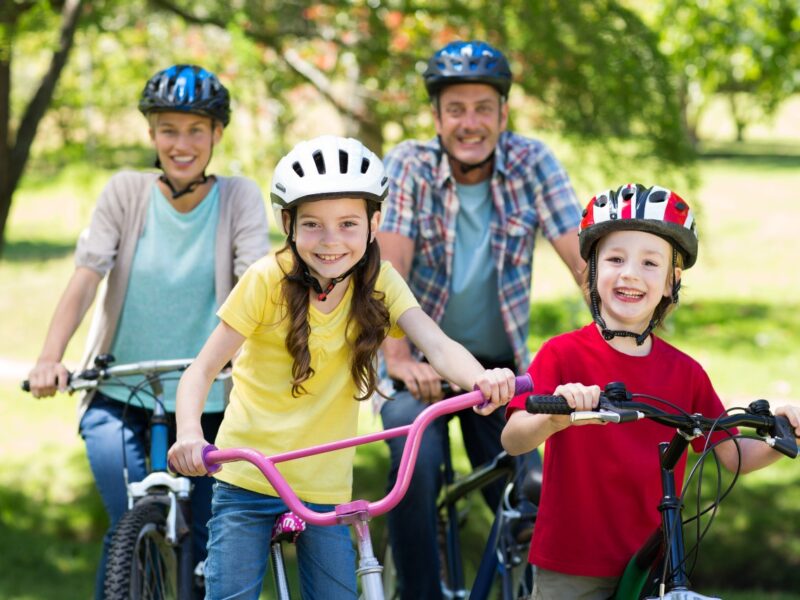 Photo of a family riding bicycles wearing helmets