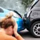 photo of a woman holding her at the scene of a car crash