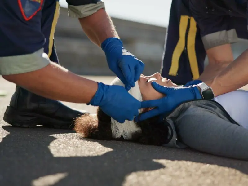 photo of paramedics treating an injured woman at a car accident scene